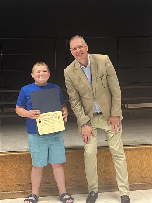 Brayden B. Smiles with his award and the District Superintendent.
